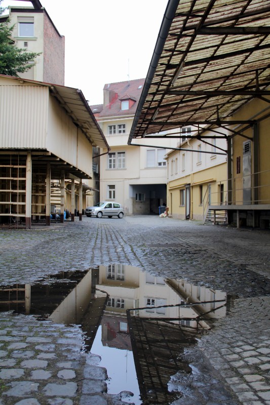 Manch ein Hinterhof bekommt eine gewisse "Schönheit" erst durch eine Spiegelung in der Pfütze.