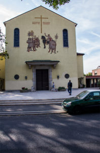 Die 1935 geweihte Heiligkreuzkirche trägt die etwas martialische Inschrift "Unter diesem Zeichen wirst Du siegen". Der Spruch war seinerzeit als Gegenstück zur Nazi-Diktatur gedacht...