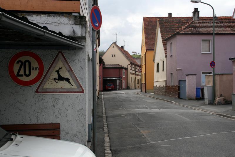 Man achte auf das rechte der beiden Schilder auf der linken Seite. Wildwechsel?! Mitten im Altort?!