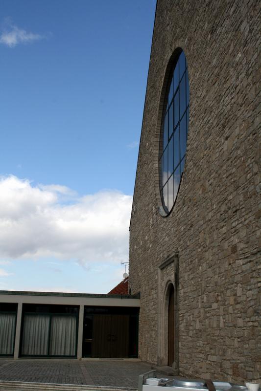 Wolken spiegeln sich im großen Lichtfenster der Kirche.