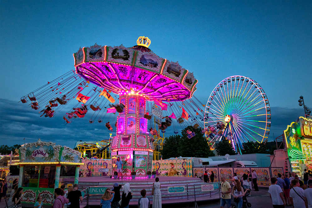 Fahrgeschäfte in der "Blauen Stunde" beim Kiliani-Volksfest 2019.