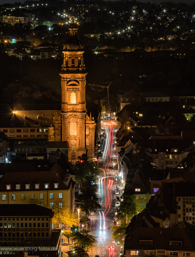Straßenverkehr und Neubaustraße bei Nacht.