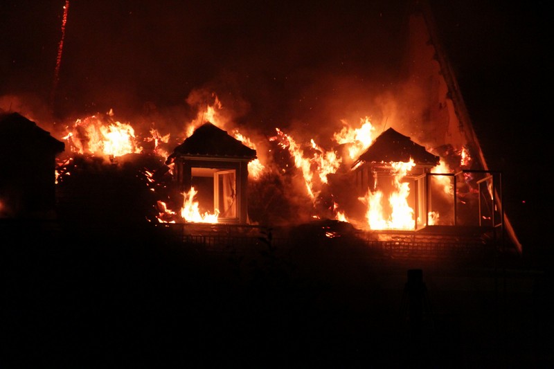 Aus den Fenstern im Dachstuhl lodern die Flammen.