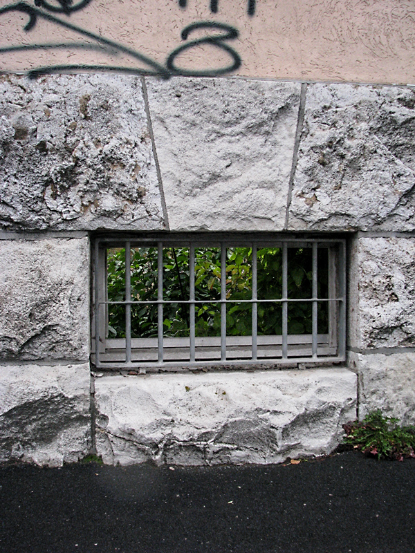 Der Blick durch das noch erhaltene Kellerfenster eines bereits abgerissenen Gebäudeteils
